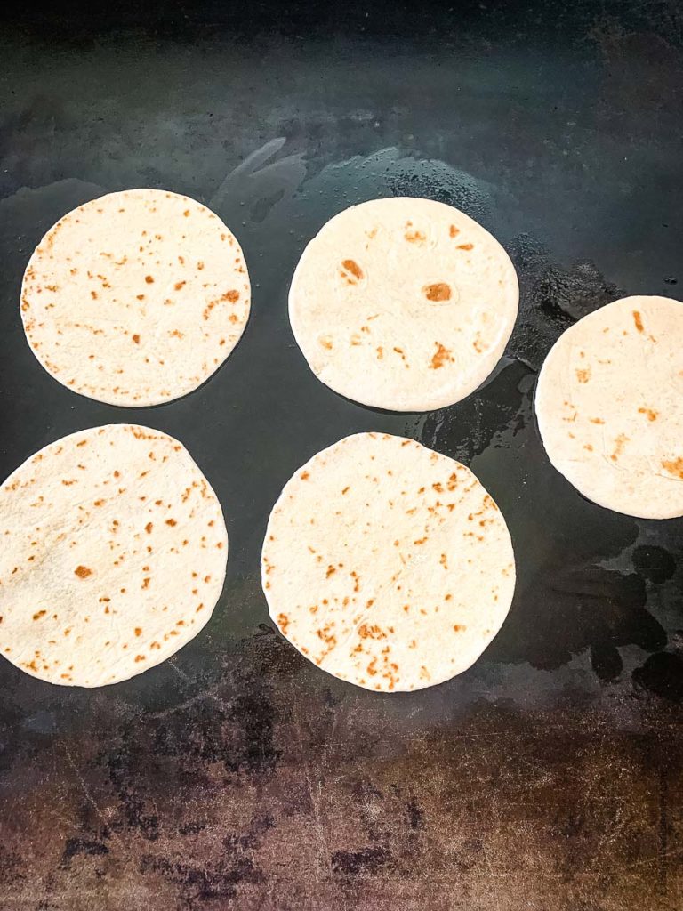 reheating the tortillas on top of a Blackstone griddle