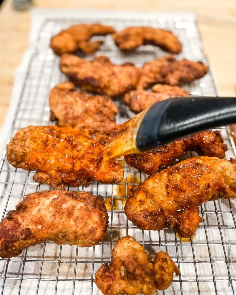 Basting spicy butter sauce on the Nashville hot chicken tenders