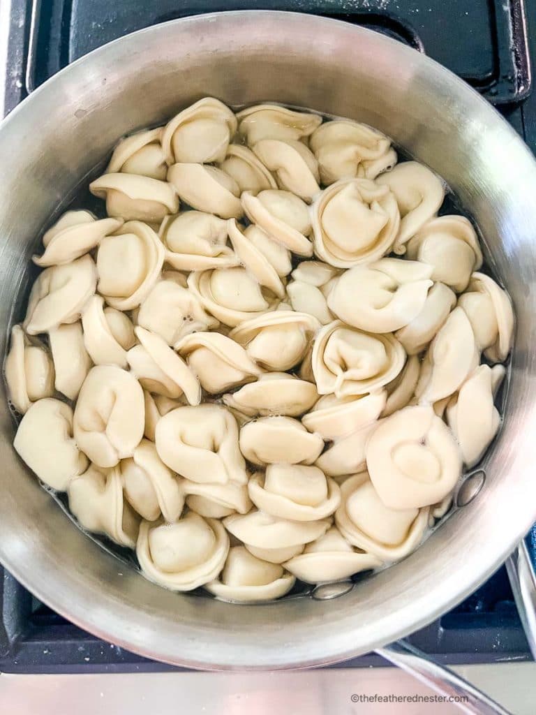 tortellini pasta cooking in a sauce pan