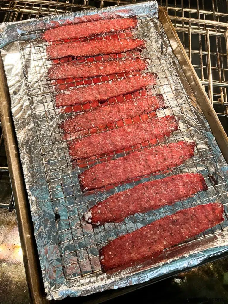 a baking rack over a baking sheet lined with foil and strips of turkey bacon