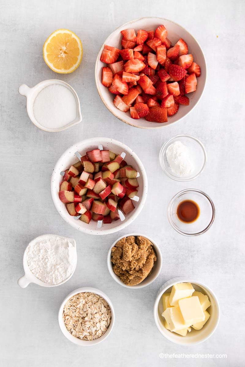 ingredients for this recipe which includes lemon, granulated sugar, chopped strawberries, chopped apples, cornstarch, flour, vanilla extract, all purpose flour, brown sugar, oats, and butter.