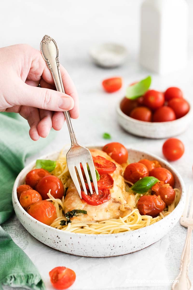 A hand holding a fork twirling pasta.