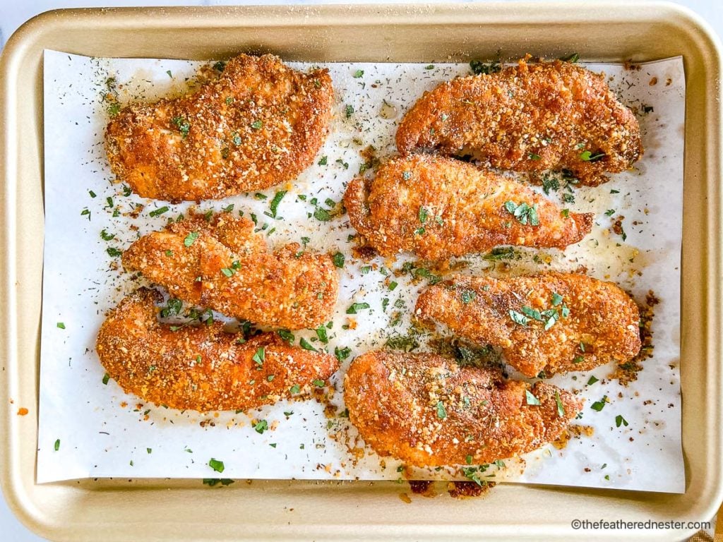 Shake and bake chicken tenders on top of parchment paper placed on a casserole