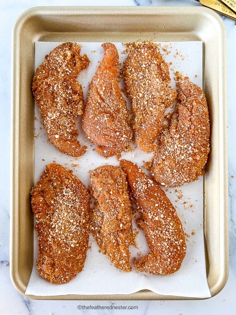 large pieces of breaded poultry on baking sheet