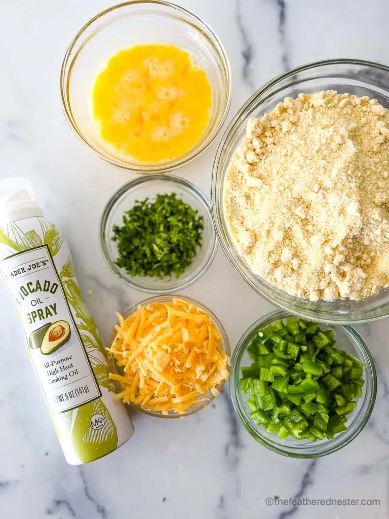 ingredients for Jiffy jalapeno cheddar cornbread which contains beaten egg, Jiffy corn mix, chopped cilantro, shredded cheddar, avocado oil spray, and diced jalapenos.