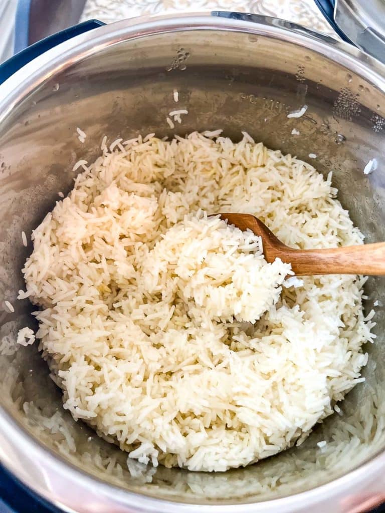 Cooked Basmati Rice in an Instant Pot with a wooden spoon.