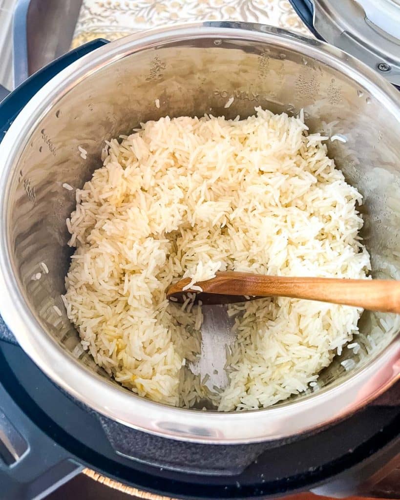 Stirring the Basmati Rice using a wood spoon in an Instant Pot.