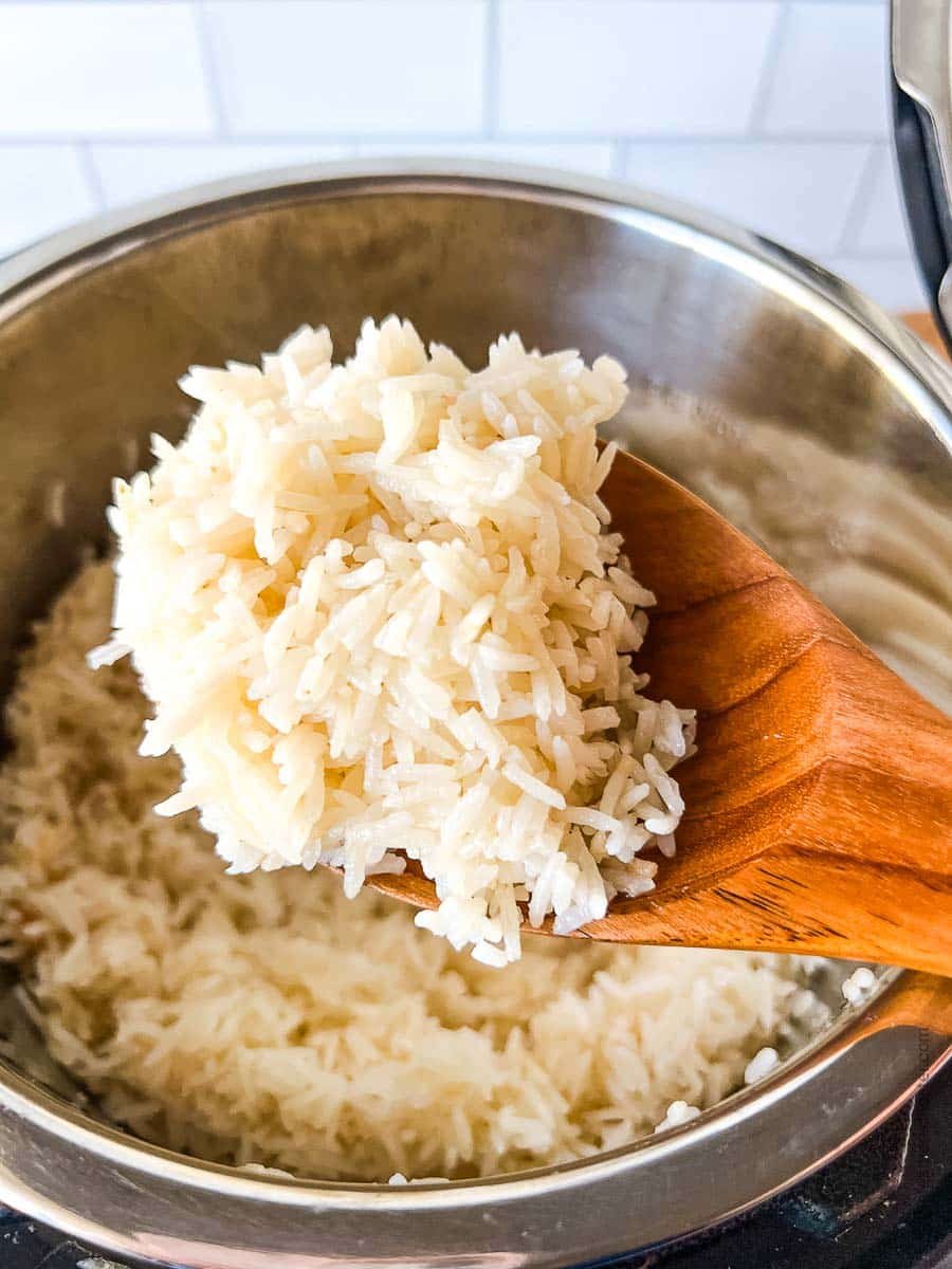 Scoopful of fluffy grains on a wooden spoon.