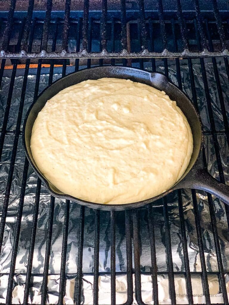 Cornbread with self rising flour batter in a cast iron skillet inside the oven.