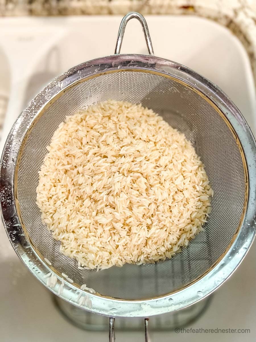 Rinsed rice in a mesh colander.