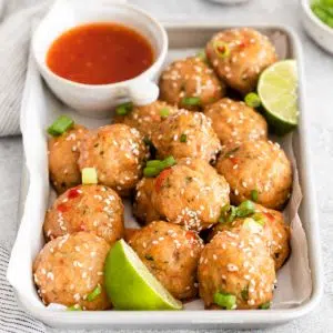 sweet chili meatballs with slices of lime places in a baking sheet