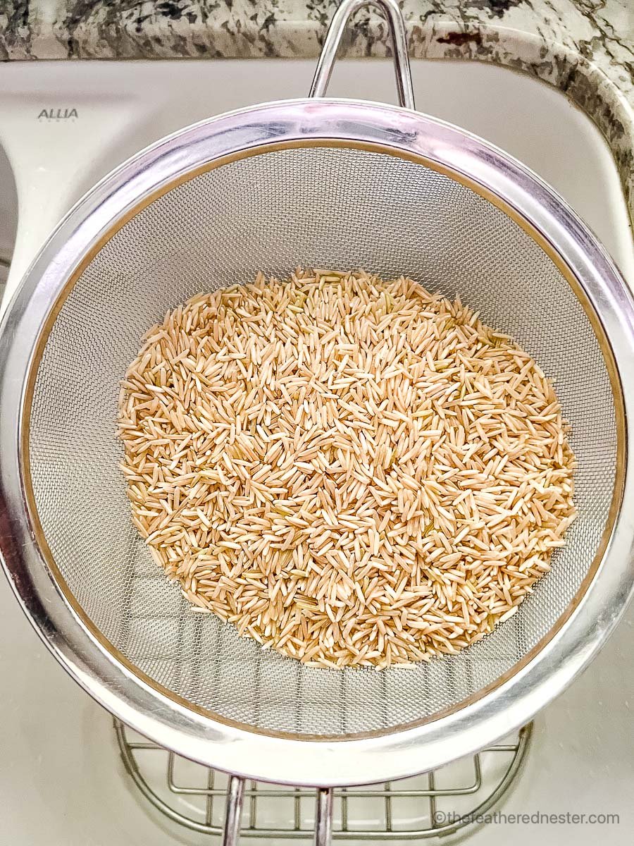 Brown rice in a mesh colander.