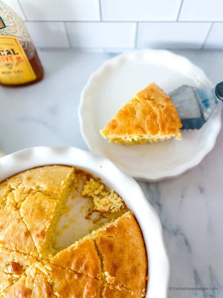 a casserole dish with Jiffy cornbread with buttermilk and a plate with slice of jiffy cornbread in it.