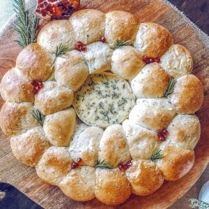 a close up photo of baked camembert and bread ring on top of a wooden board.