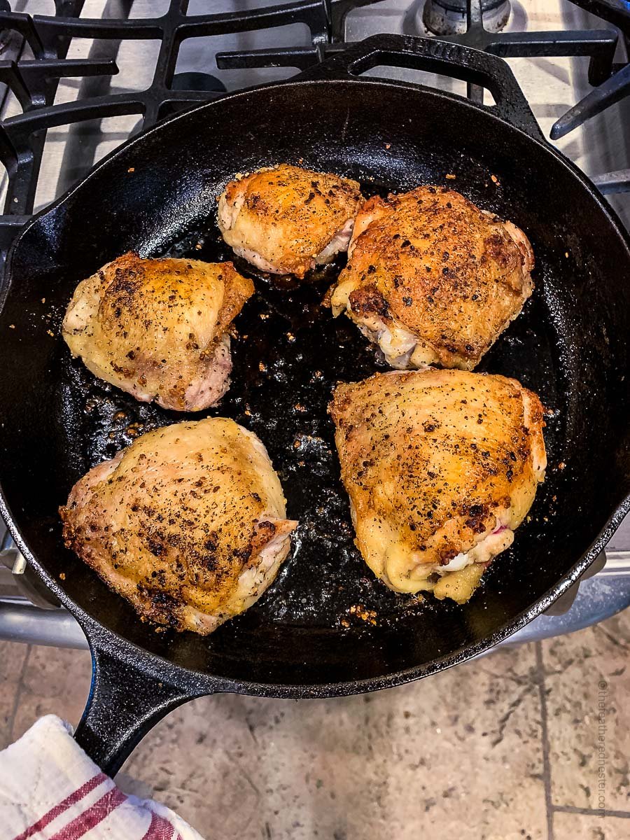 golden brown chicken thighs on a skillet.