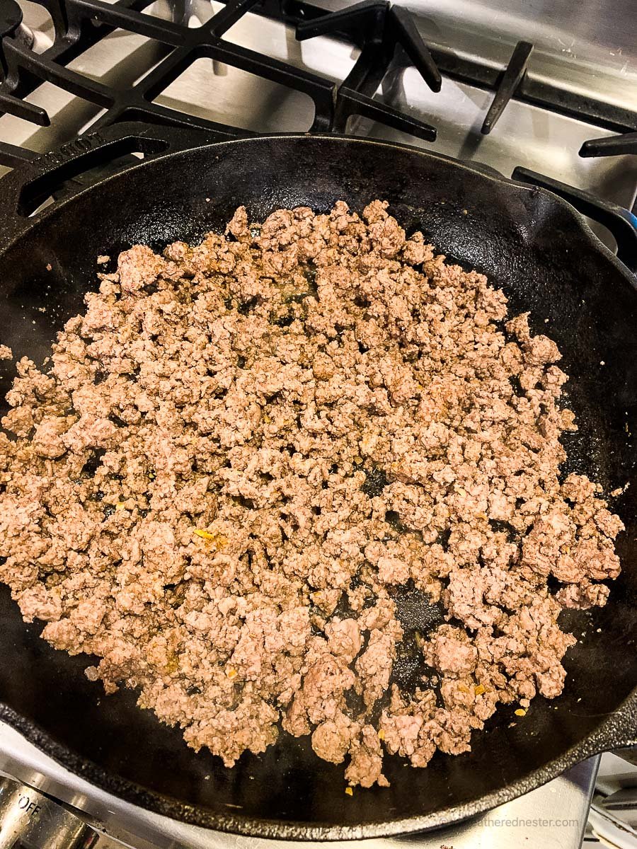 a cast iron skillet with browned ground beef