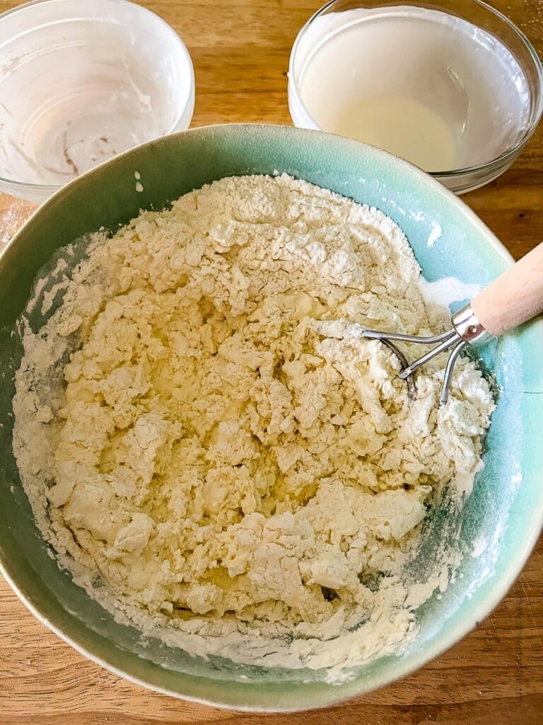 a green bowl of biscuit dough.