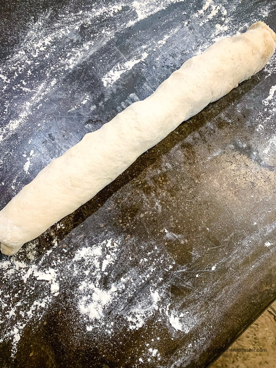 Log shaped dough on a countertop.