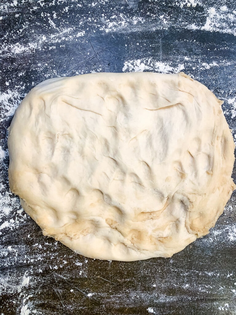 sourdough rolls dough mixture on a floured countertop.