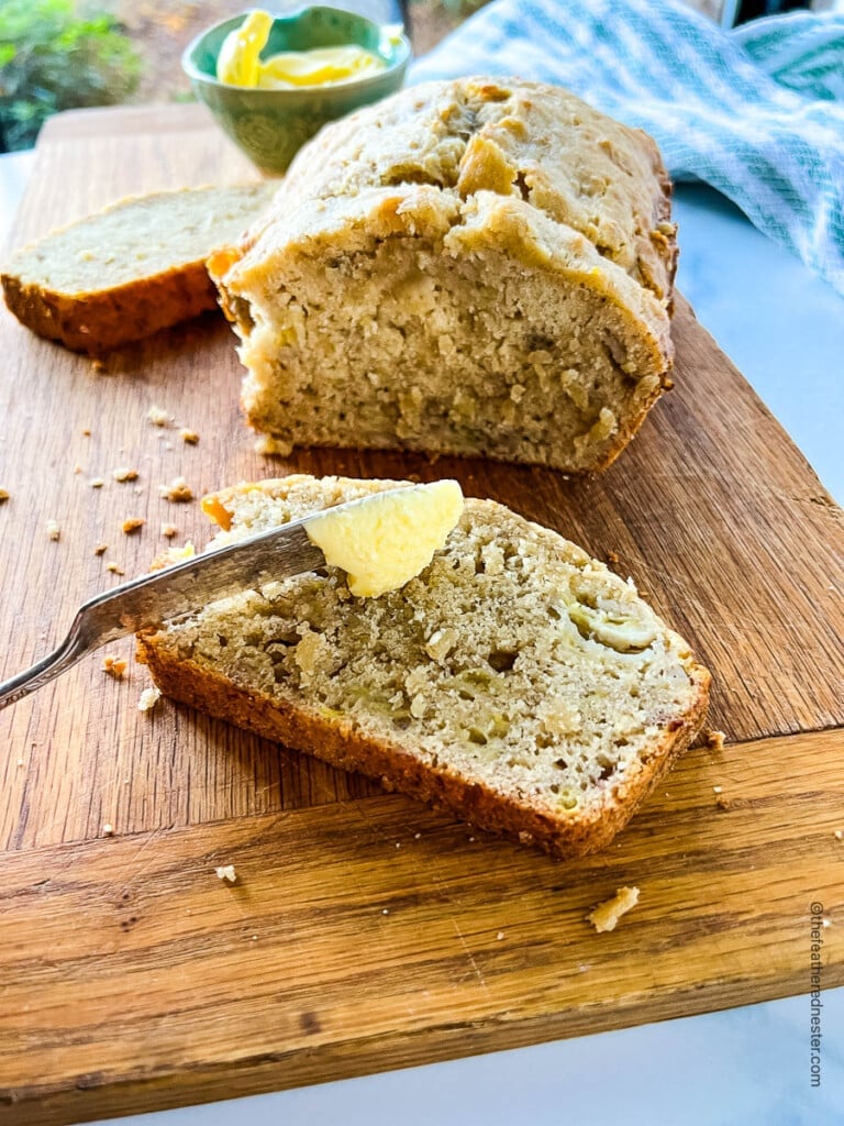 spreading butter on a slice of bisquick banana bread