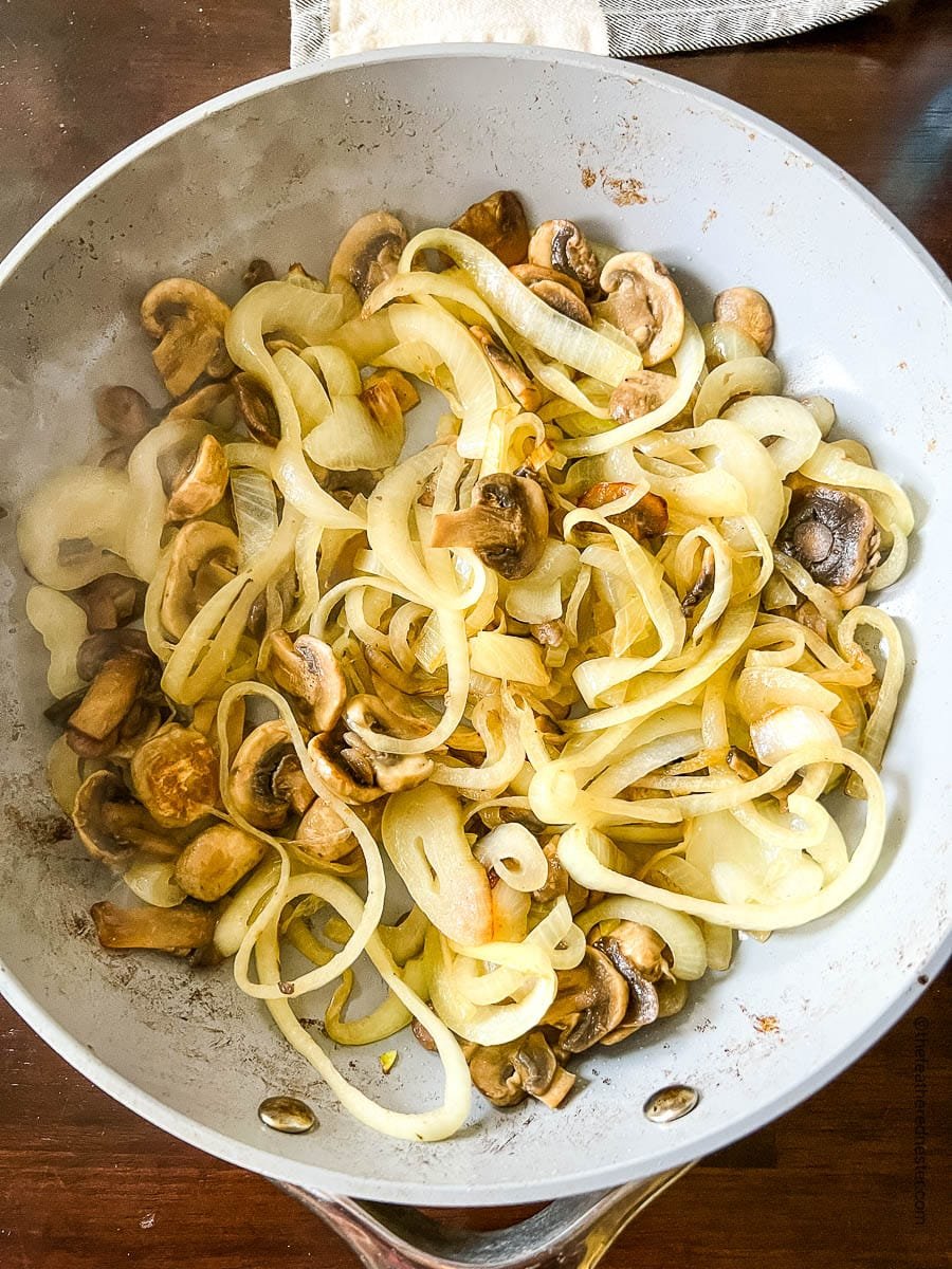 Sautéing mushrooms and onions in a skillet.
