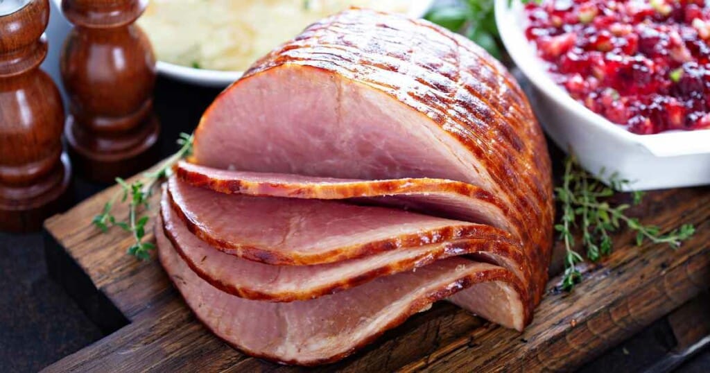 fully cooked Dr. Pepper Ham on a wooden carving board.