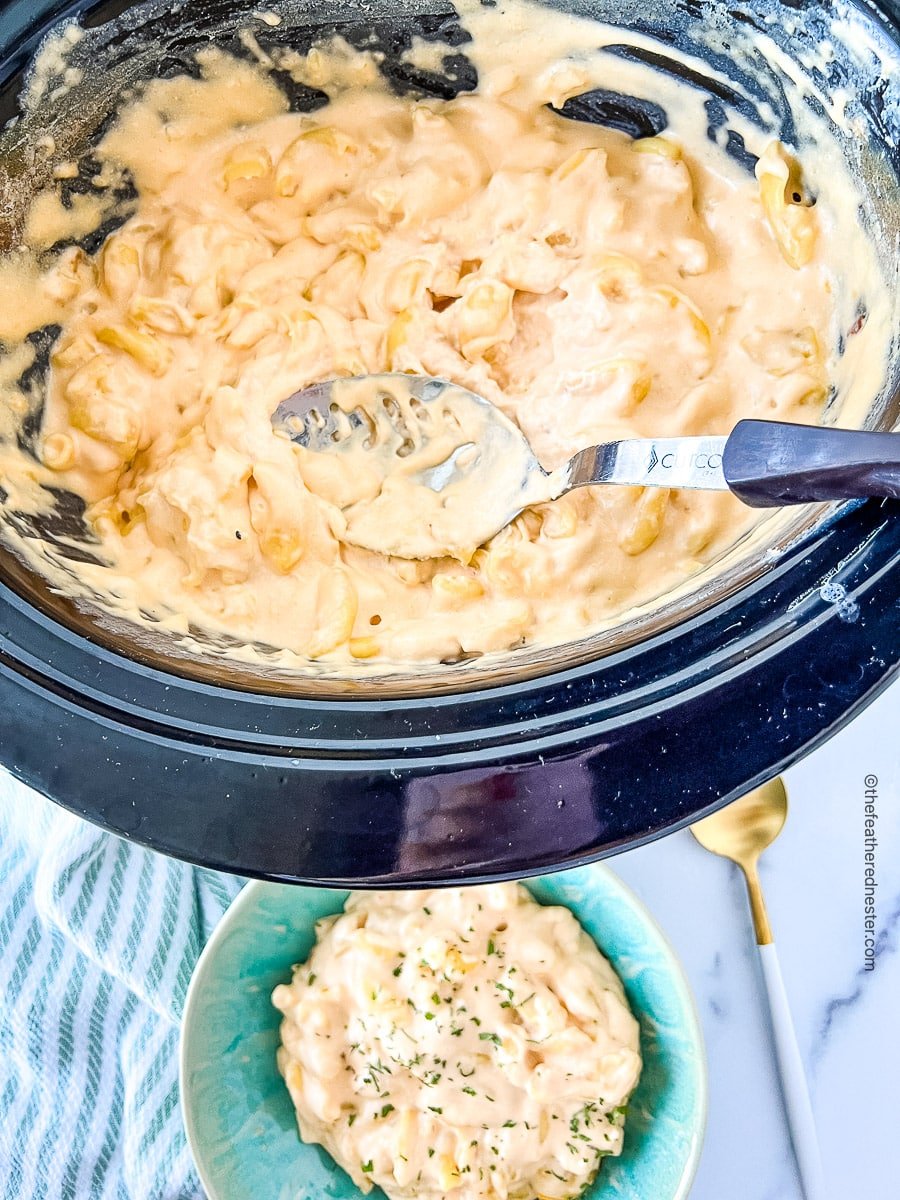 serving spoon in a pot full of cheesy pasta