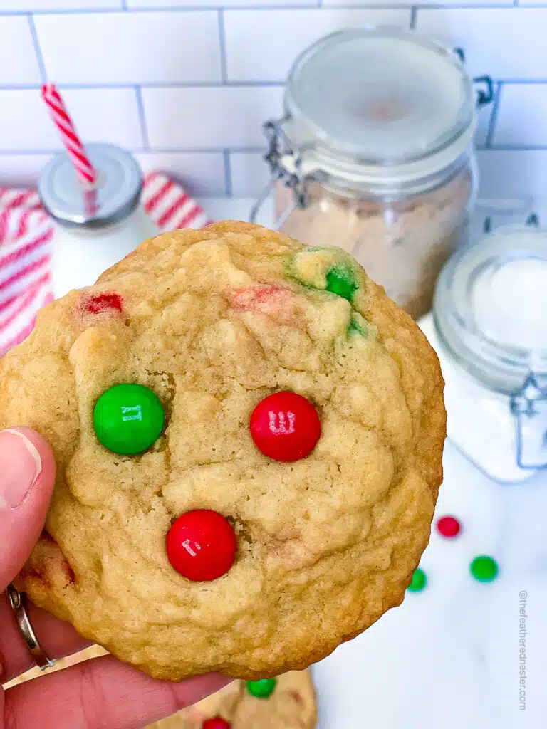 a hand holding a Christmas M&M Cookie.