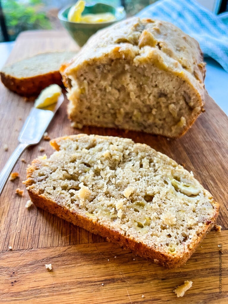 a slice of Bisquick banana bread in front of the remaining loaf.
