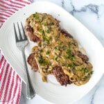 Country style steak with mushroom gravy on a platter.