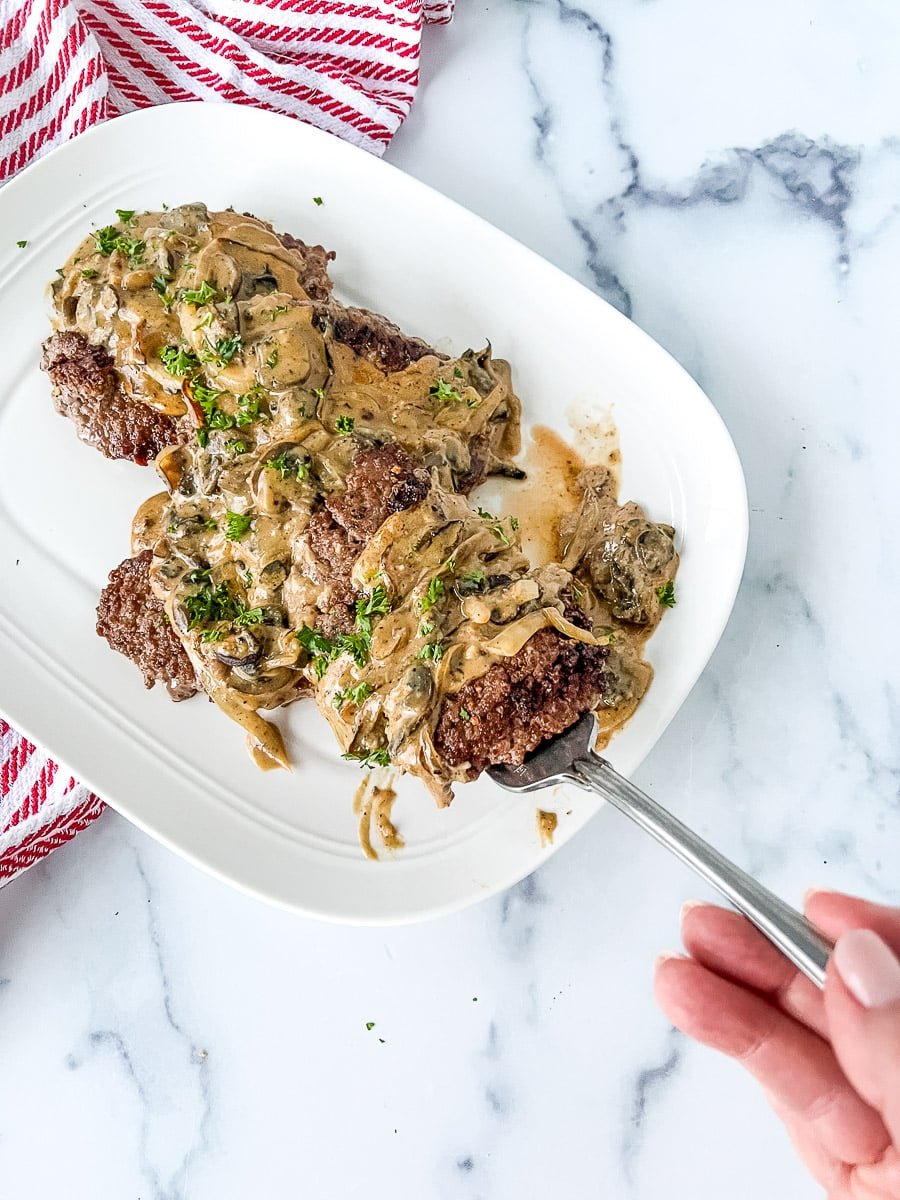 Slow cooker cube steaks with gravy on a serving plate.