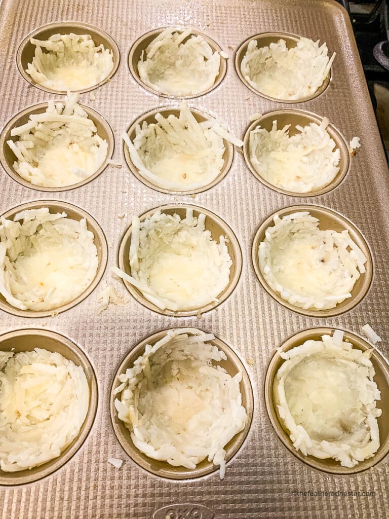 raw shredded potatoes pressed into a muffin pan.