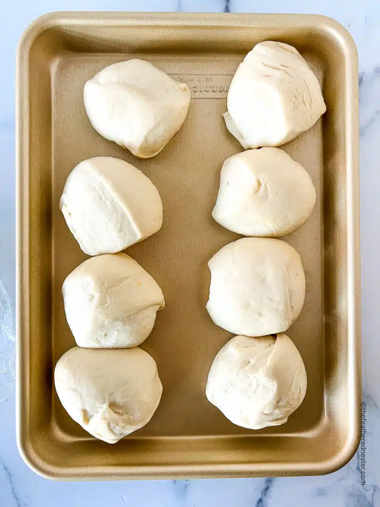 8 thawed dough balls on a baking sheet.