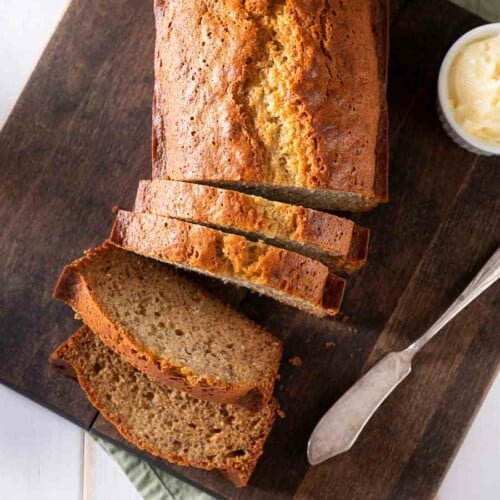 a loaf of sliced banana bread on a wooden cutting board.