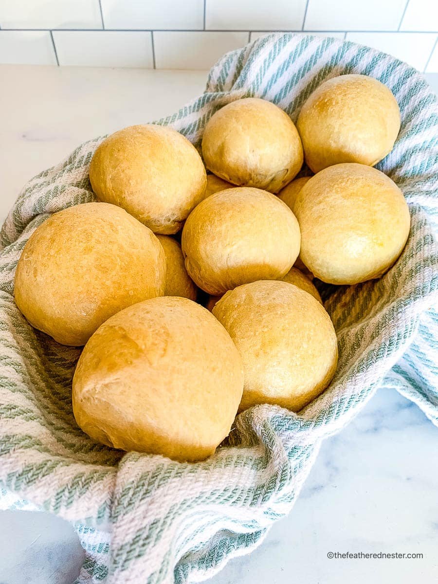 Homemade rolls on a striped kitchen towel.