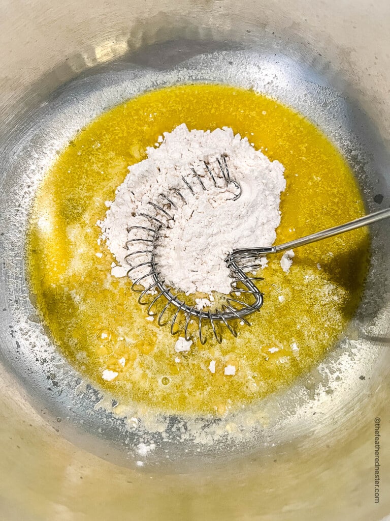 adding flour to melted butter in a saucepan.