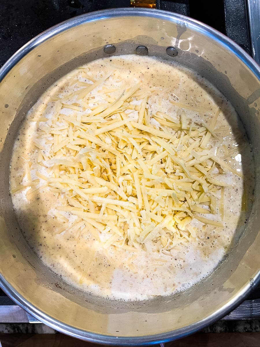 white cheese melting in a pot with bechamel.