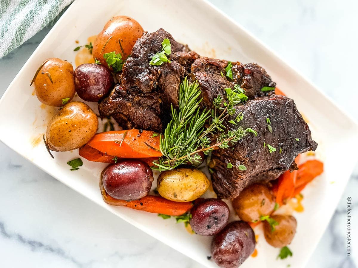 A plate of dutch oven pot roast with potatoes and carrots