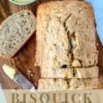 a sliced loaf of banana bread on a wooden board with a bowl of butter to the side with writings at the bottom part that says "bisquick banana bread www.thefeatherednester.com"