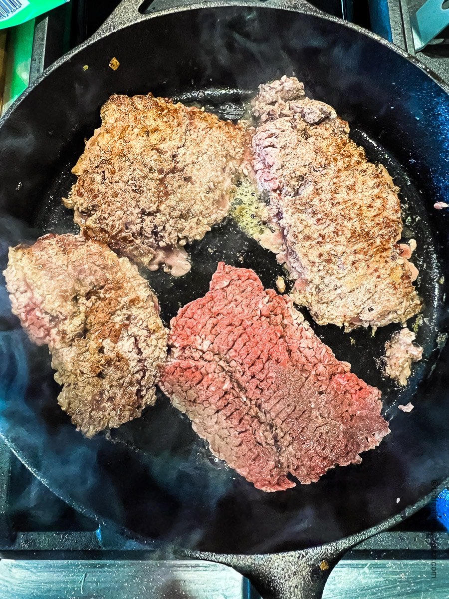 Browning cube steaks in a skillet.