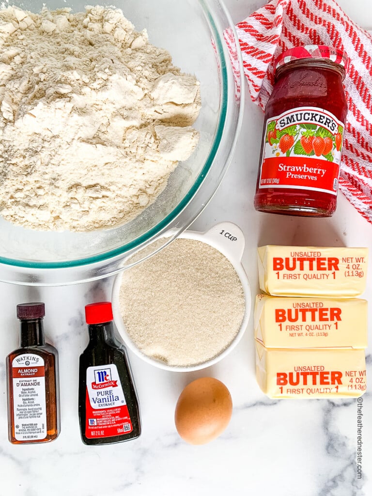 Ingredients for Valentine's Day cookie recipe : all-purpose flour, strawberry jam, unsalted butter, granulated sugar, egg, almond extract and vanilla extract.