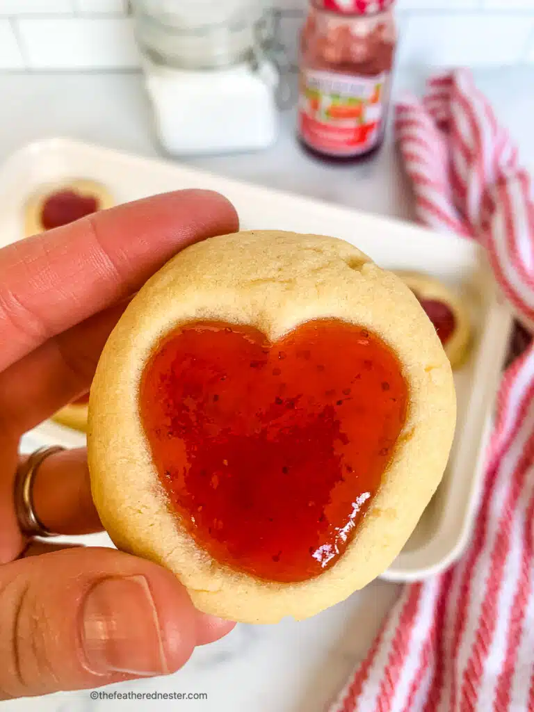 a hand holding a Valentine's Day cookie