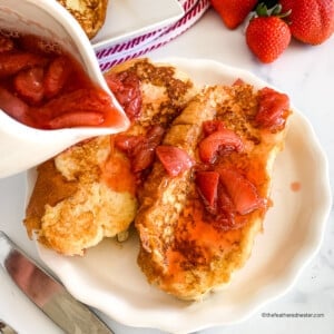 pouring syrup over homemade strawberry French toast.