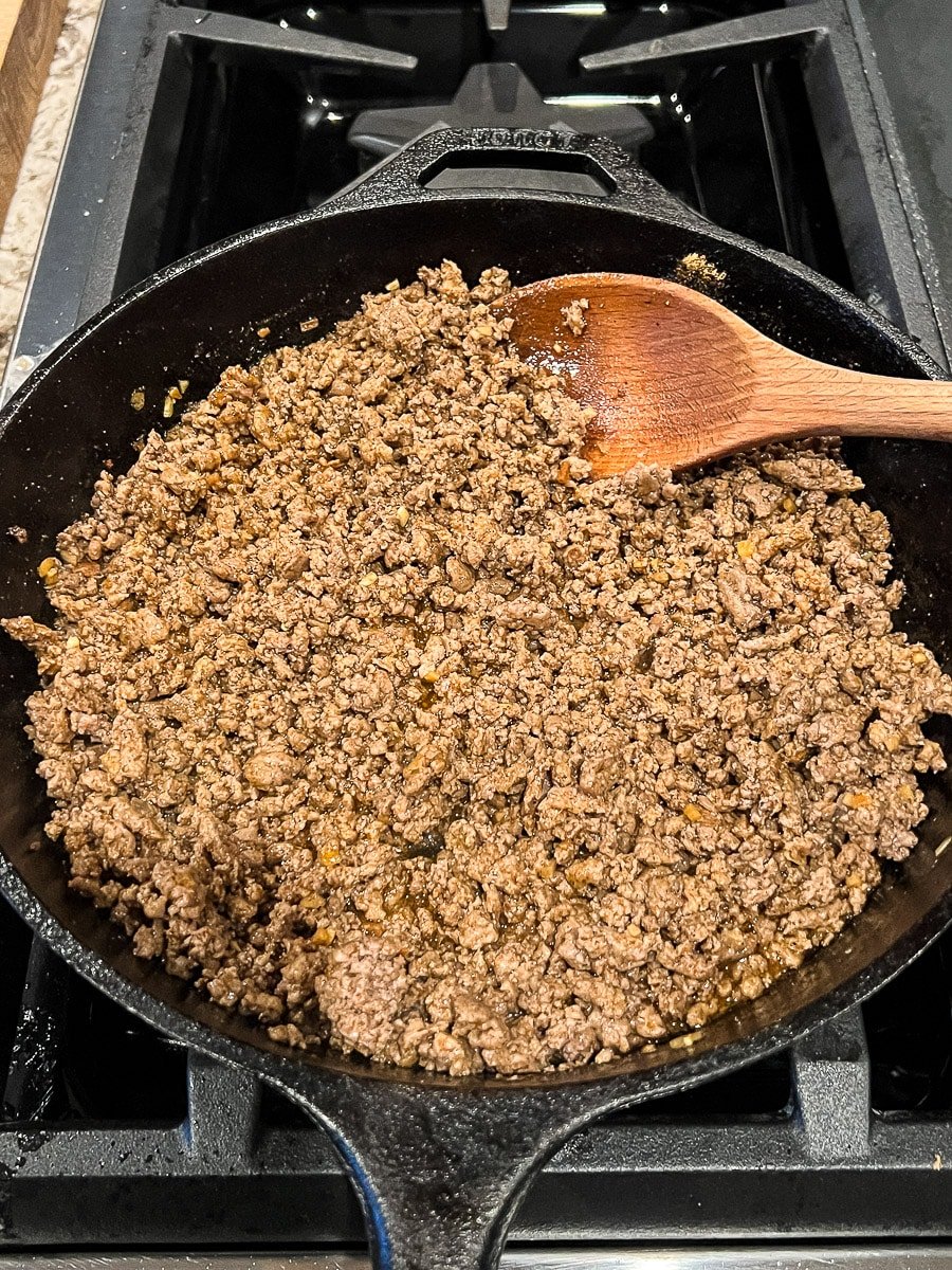 Browned ground beef in a cast iron skillet.