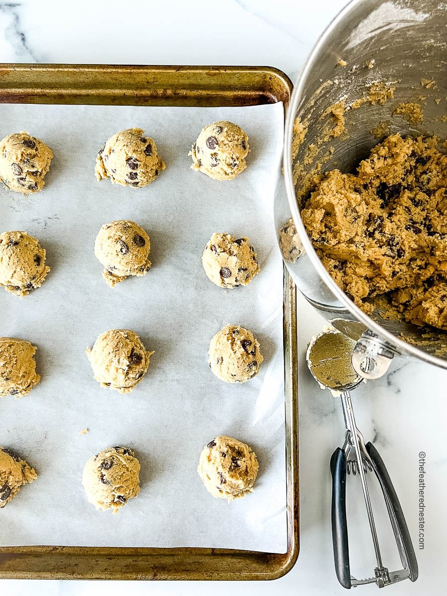Scooping dough onto a baking sheet for a soft cookie recipe.