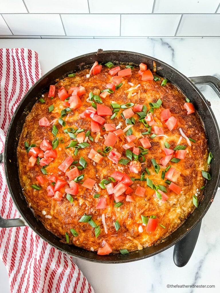 Tex Mex casserole topped with diced tomatoes and scallions.