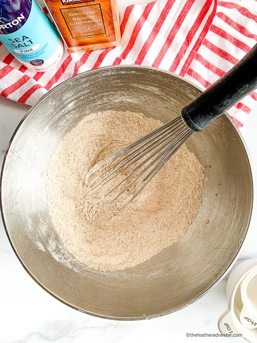 Mixing cinnamon muffin recipe ingredients in a mixing bowl.