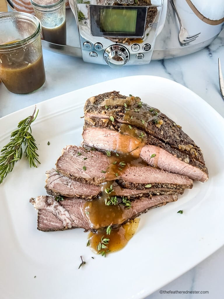 Brown gravy over slices of beef pot roast made in a crock pot.