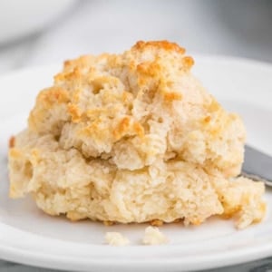 A piece of drop biscuit on a white plate.
