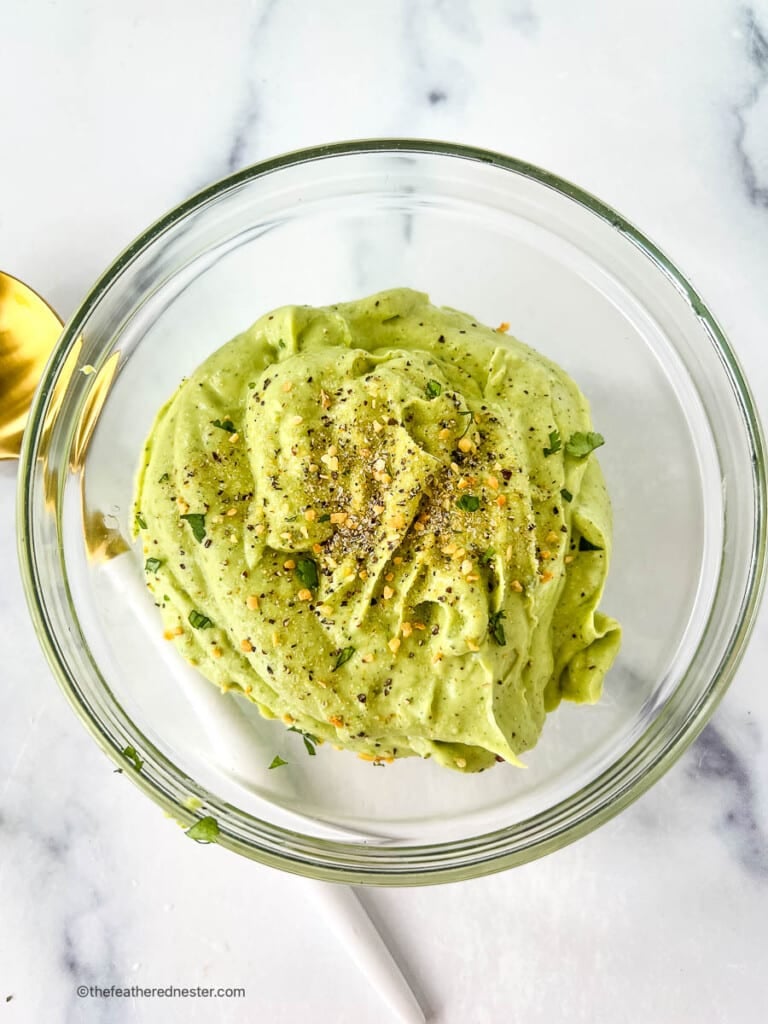 Avocado crema party food in a round glass dish.